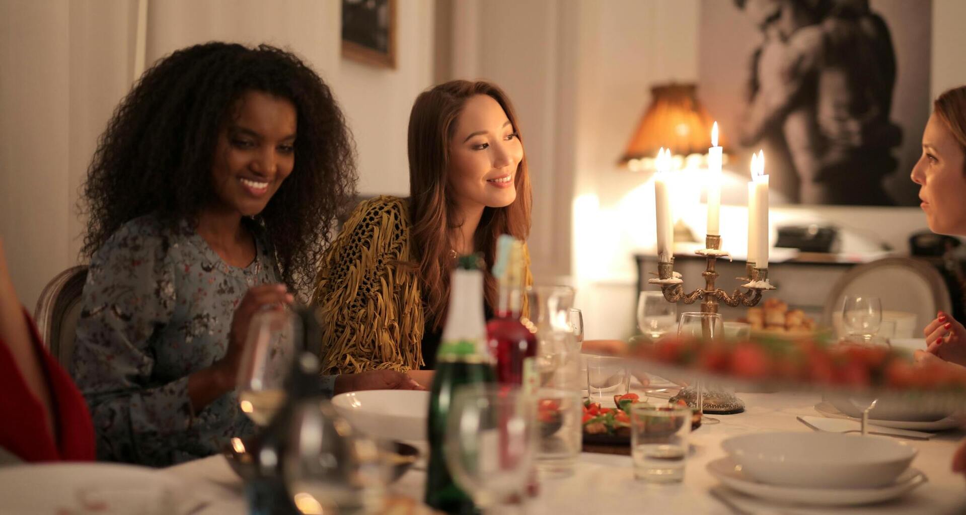 Groupes d'amies qui sont entrain de souper avec un verre de vin fait par l'hôte